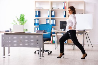 Ofis egzersizleri yapıyor orta yaşlı kadın işçiye 