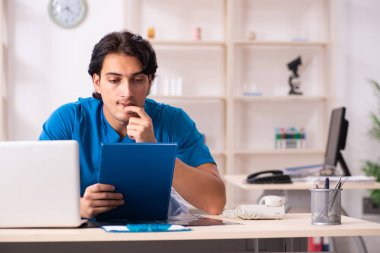 Klinikte çalışan yakışıklı genç bir doktor. 