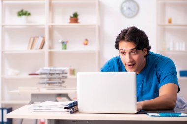 Klinikte çalışan yakışıklı genç bir doktor. 