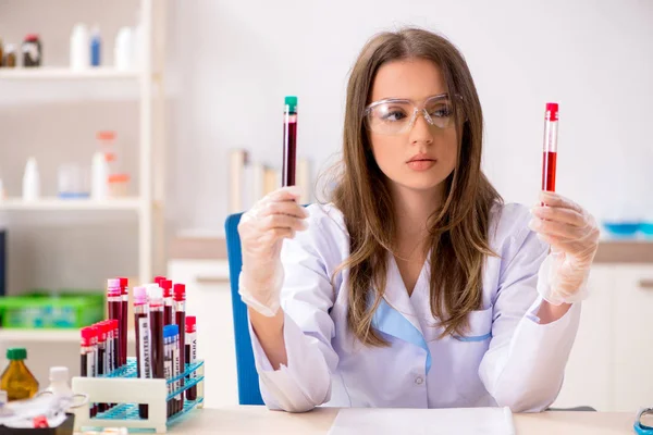 Joven hermosa asistente de laboratorio de análisis de muestras de sangre —  Fotos de Stock