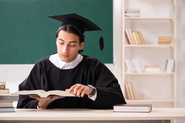 Graduate student in front of green board — Stock Photo, Image