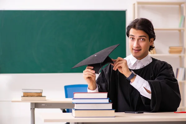 Estudante graduado na frente do quadro verde — Fotografia de Stock