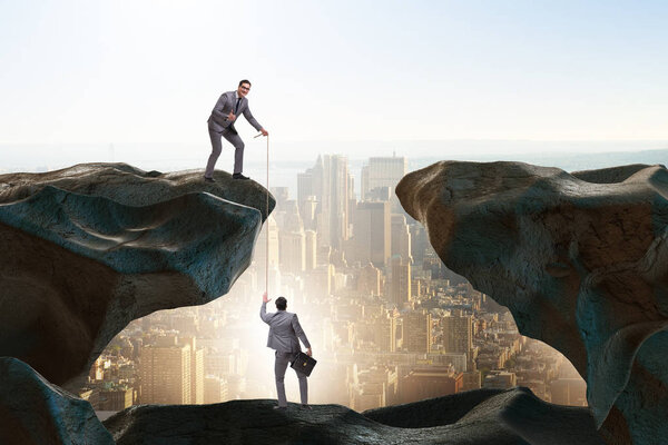 Businessman helping colleague with rope