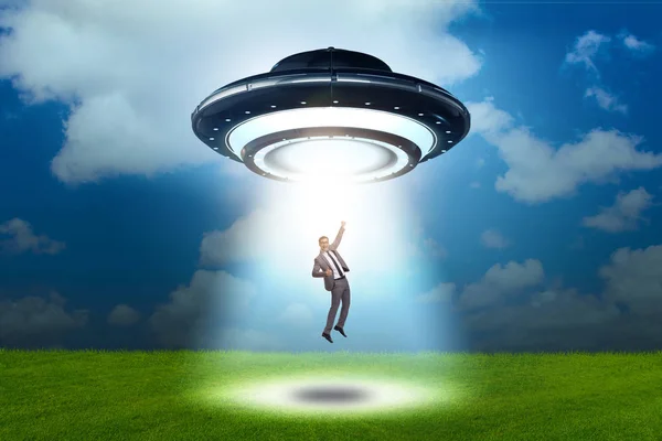 Flying saucer abducting young businessman — Stock Photo, Image