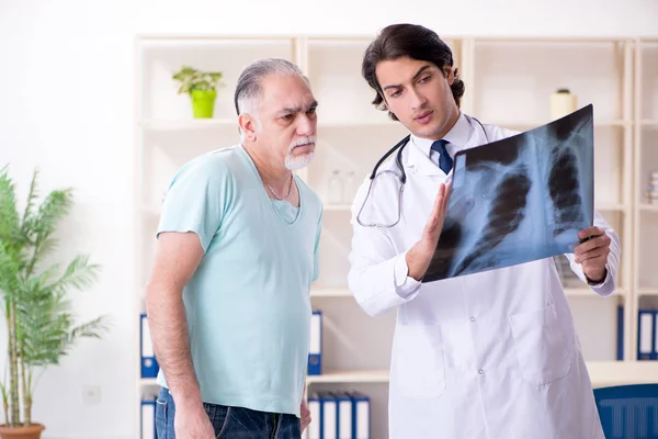 Gamle man besöker ung manlig läkare — Stockfoto