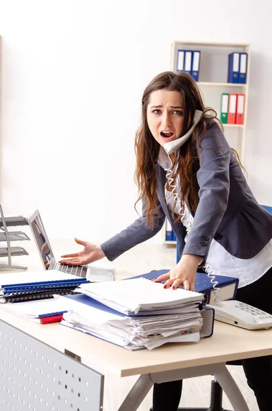 Jonge vrouwelijke werknemer ongelukkig met buitensporige werk — Stockfoto