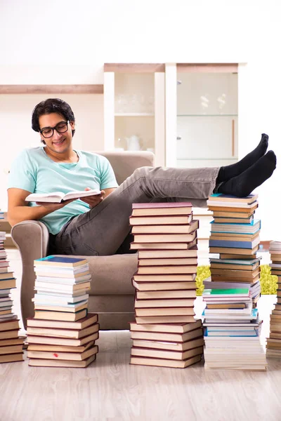 Мужчина студент с большим количеством книг на дому — стоковое фото