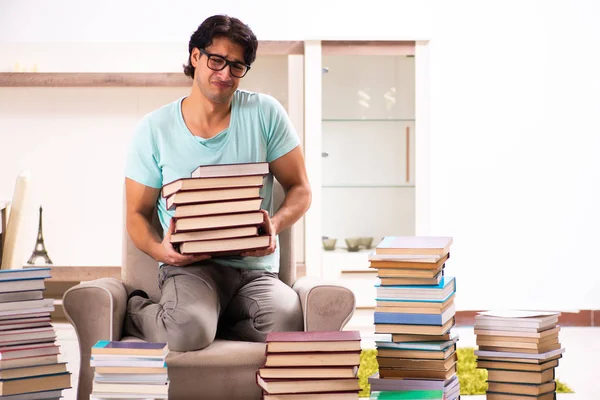 Estudiante masculino con muchos libros en casa — Foto de Stock