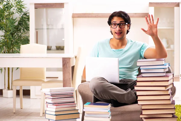 Estudante do sexo masculino com muitos livros em casa — Fotografia de Stock