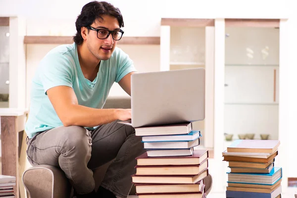 Estudante do sexo masculino com muitos livros em casa — Fotografia de Stock