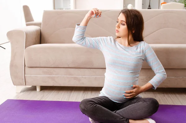 Giovane donna incinta che fa esercizi sportivi a casa — Foto Stock