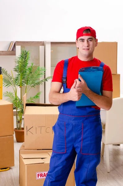 Jovem empreiteiro com caixas de trabalho dentro de casa — Fotografia de Stock