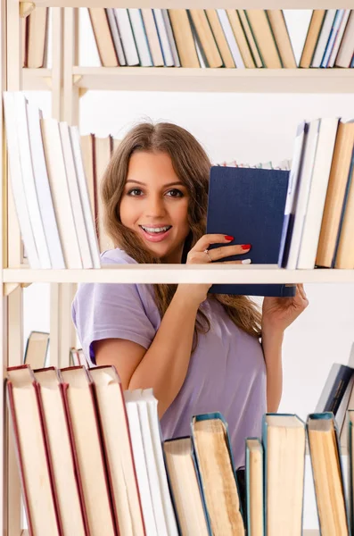 Jovem estudante se preparando para exames na biblioteca — Fotografia de Stock