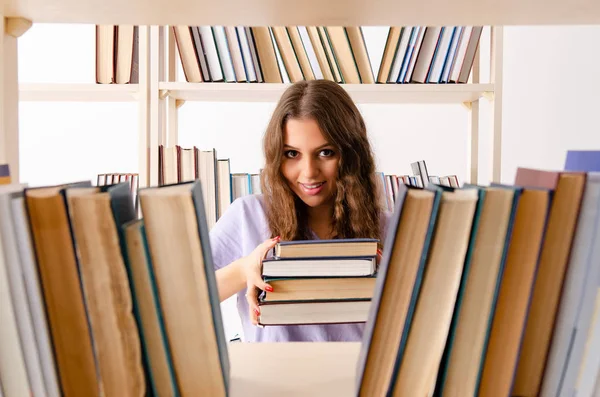 Jovem estudante se preparando para exames na biblioteca — Fotografia de Stock