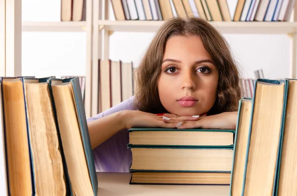 Joven estudiante preparándose para los exámenes en la biblioteca — Foto de Stock