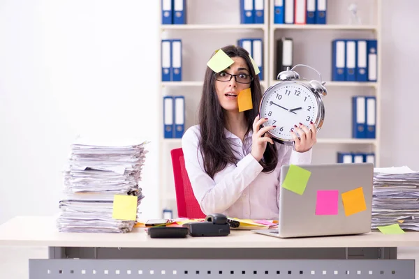 Young female employee in conflicting priorities concept — Stock Photo, Image