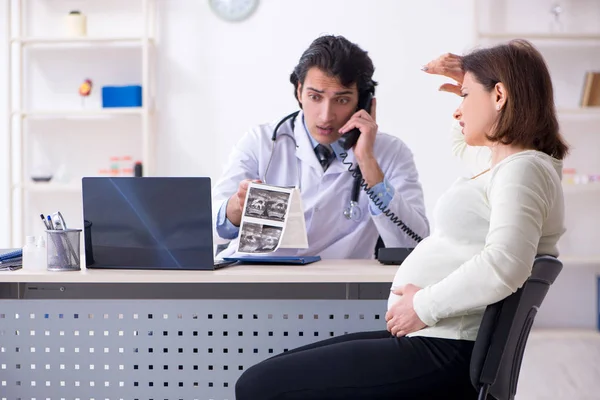 Vecchia donna incinta in visita giovane medico maschio — Foto Stock