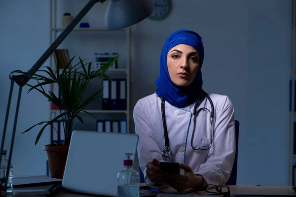夜の診療所で働くアラブ女性医師 — ストック写真