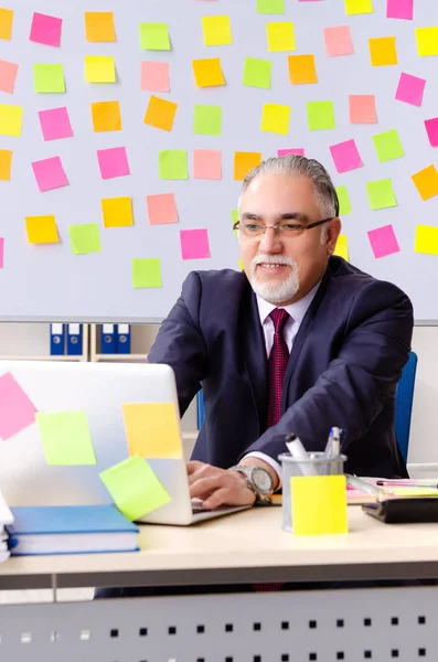 Dipendente uomo anziano in concetto di priorità contrastanti — Foto Stock