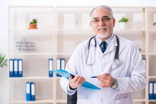 Åldrad manlig läkare som arbetar på kliniken — Stockfoto