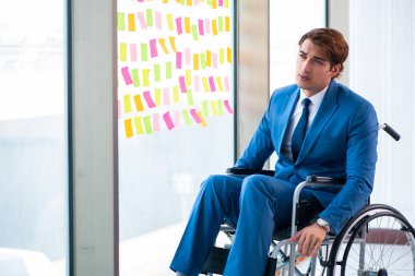 Birçok çelişkili önceliği olan tekerlekli sandalyedeki genç yakışıklı adam.