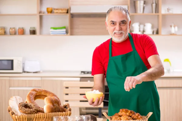 Oude mannelijke baker werken in de keuken — Stockfoto