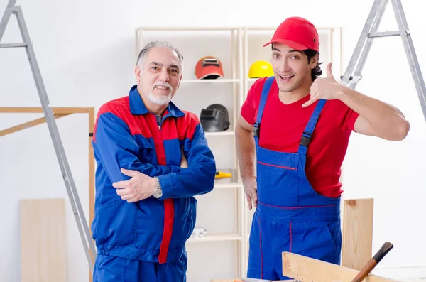 Dois empreiteiros profissionais que colocam piso em casa — Fotografia de Stock