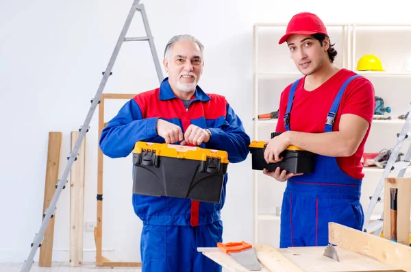 Two professional contractors laying flooring at home