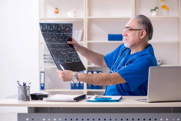 Beyaz sakallı yaşlı doktor radyolog klinikte çalışan — Stok fotoğraf