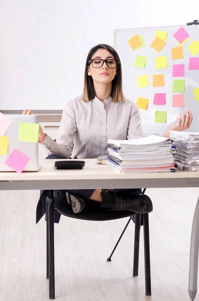 Jovem funcionária fazendo exercícios no local de trabalho — Fotografia de Stock