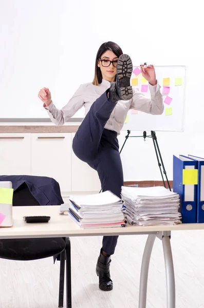 Молода жінка-працівник виконує вправи на робочому місці — стокове фото