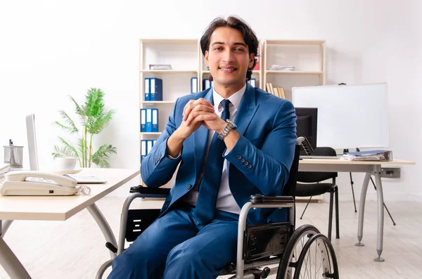 Mannelijke werknemer in rolstoel werken op kantoor — Stockfoto