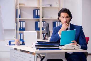 Genç yakışıklı işadamı ofiste çalışıyor.