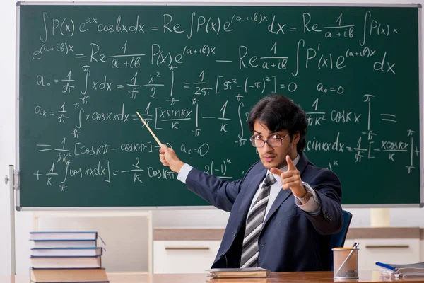 Genç erkek matematik öğretmeni sınıfta 