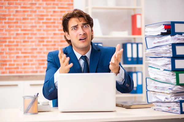 Joven hombre elegante infeliz con demasiado trabajo — Foto de Stock