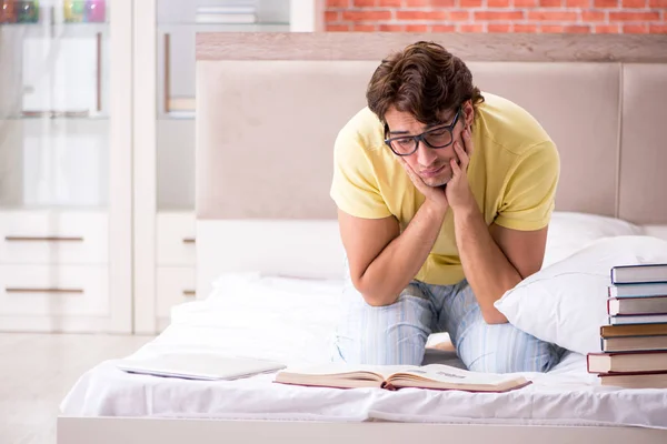 Giovane studente che studia a letto per gli esami — Foto Stock