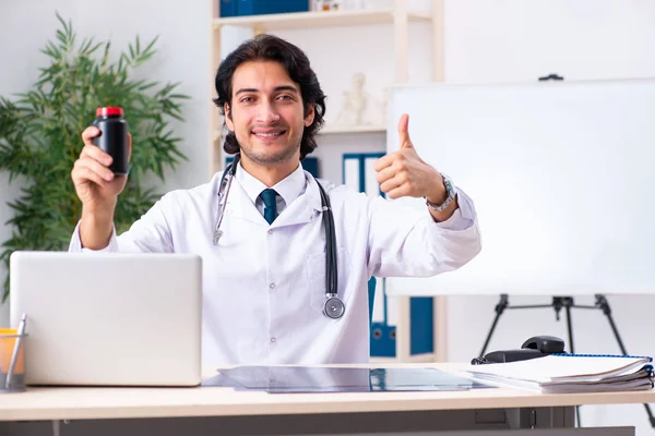 Jovem médico bonito que trabalha na clínica — Fotografia de Stock