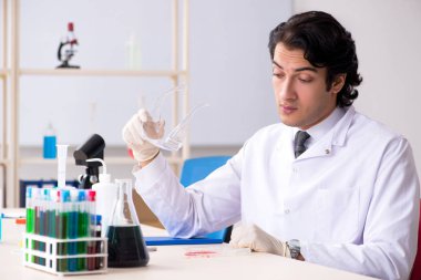 Laboratuvarda çalışan yakışıklı bir kimyager. 