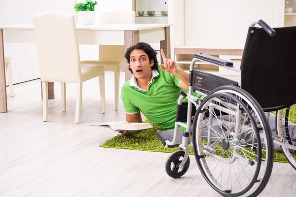 Junger schöner Mann im Rollstuhl zu Hause — Stockfoto