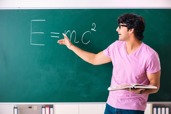 Junge männliche Physik vor dem grünen Brett — Stockfoto