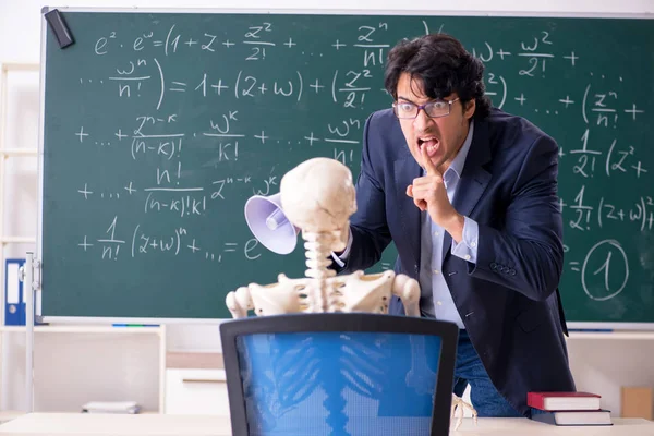 Молодой учитель математики и студенческий скелет — стоковое фото