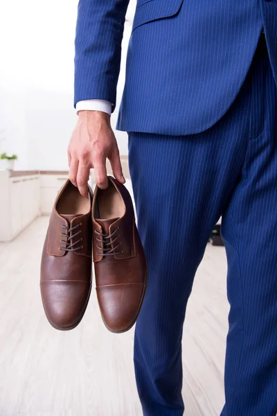 Young handsome businessman choosing shoes at home — Stock Photo, Image