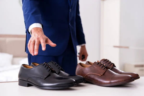 Jovem empresário bonito escolhendo sapatos em casa — Fotografia de Stock