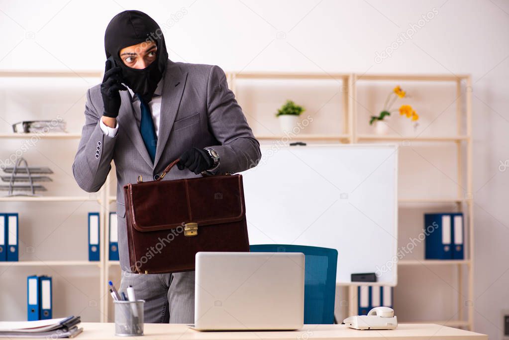 Male gangster stealing information from the office 