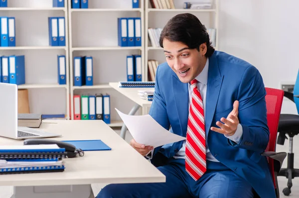 Jong gelukkig mannelijk werknemer in het kantoor — Stockfoto