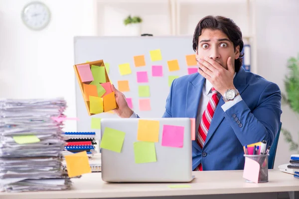 Jonge mannelijke knappe werknemer in tegenstrijdige prioriteiten concept — Stockfoto