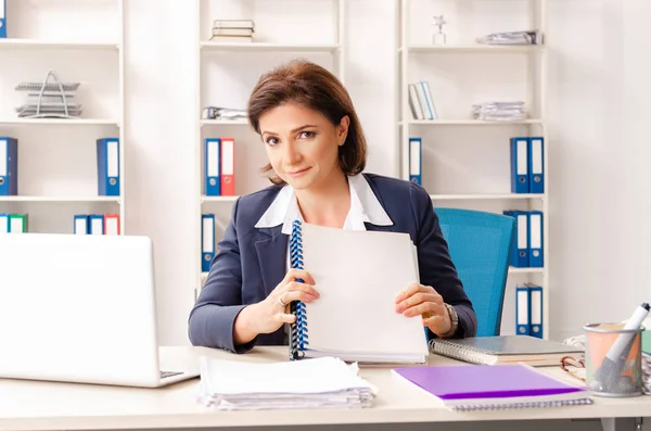 Mitarbeiterin mittleren Alters sitzt im Büro — Stockfoto