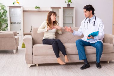 Genç, yakışıklı doktor, kadın hastayı evinde ziyaret ediyor. 