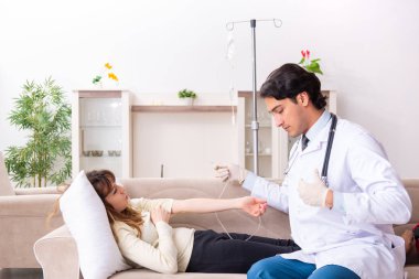 Genç, yakışıklı doktor, kadın hastayı evinde ziyaret ediyor. 