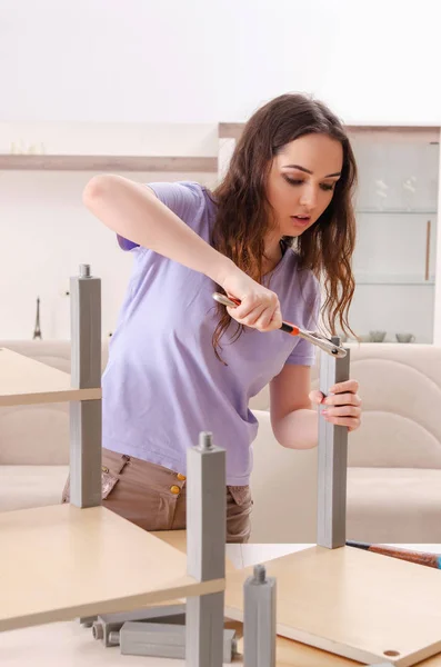 Jonge vrouw repareert stoel thuis — Stockfoto